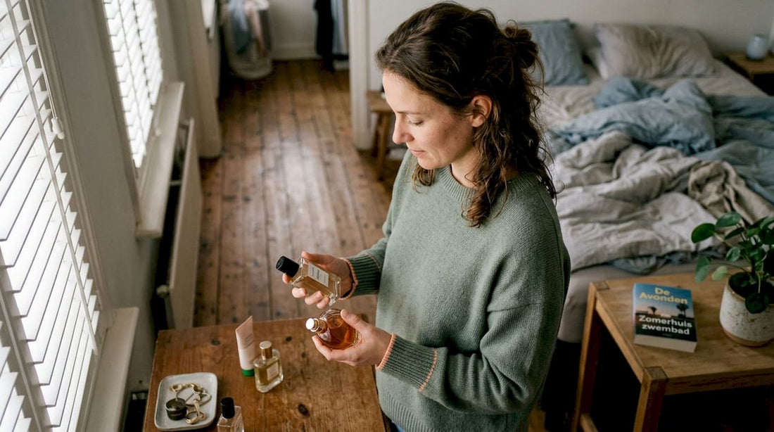 Een vrouw staat voor haar kaptafel te twijfelen tussen twee verschillende geurtjes.