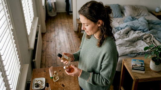 Een vrouw staat voor haar kaptafel te twijfelen tussen twee verschillende geurtjes.